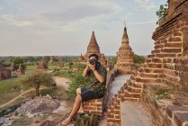 Молодой человек делает фото вокруг древнего храма Пятадар, Баган, Мьянма — стоковое фото