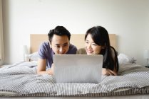 Adulto asiático casal usando laptop juntos em casa — Fotografia de Stock