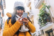 Giovane attraente asiatico donna utilizzando smartphone su strada — Foto stock