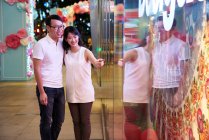 Щаслива молода азіатська сім'я вказує на щось в торговому центрі — стокове фото