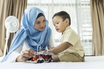 Jeune asiatique musulman mère et enfant avoir amusant à la maison avec jouets — Photo de stock