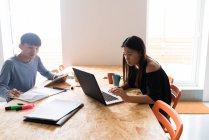 Молодые азиатские люди, работающие вместе с ноутбуком в офисе — стоковое фото