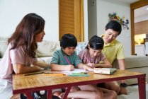 RILASCIO Felice giovane famiglia asiatica insieme disegno a casa — Foto stock