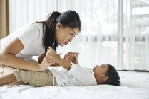 Asiatique mère collage avec son fils sur l 'lit — Photo de stock