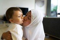Mutter im Hijab spielt mit ihrem Sohn im Wohnzimmer — Stockfoto