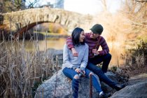 Молодая пара, сидящая и отдыхающая в центральном парке, Нью-Йорк, США — стоковое фото