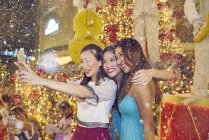 Молоді привабливі азіатські жінки на різдвяних покупках приймають селфі — стокове фото