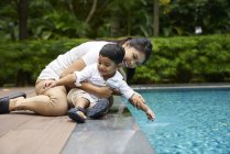 Азіатська мати і син зв'язаний біля басейну — стокове фото
