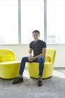 Jovem asiático homem de negócios no trabalho no escritório moderno — Fotografia de Stock