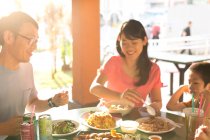 Щаслива азіатська сім'я їсть разом у кафе — стокове фото