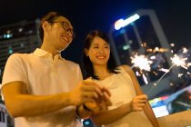 РЕЛИЗ Молодая азиатская пара вместе с бенгальскими огнями на китайский Новый год — стоковое фото