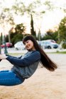 Young eurasian woman riding swing at park in barcelona — Stock Photo