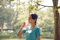 Mulher hidratante após o exercício em Jardins Botânicos, Cingapura — Fotografia de Stock