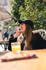 Молода красива жінка використовує смартфон у кафе — стокове фото