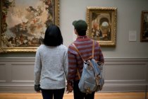 Rear view of asian tourists looking on pictures in The Metropolitan Museum of Art, New York, USA — Stock Photo