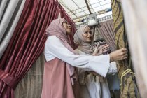 Two muslim ladies shopping for curtains. — Stock Photo