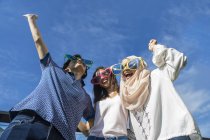 Gruppe von Freunden mit lustigen Brillen amüsiert sich vor blauem Himmel — Stockfoto