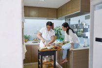 RELEASES Happy young asian couple cooking together — Stock Photo