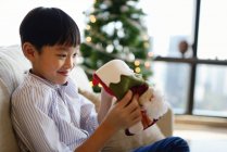 Feliz asiático chico celebrando Navidad en casa - foto de stock