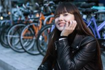 Retrato de jovem atraente mulher asiática na cidade na frente de bicicletas — Fotografia de Stock