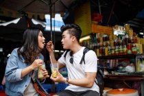 Young couple having dessert at a local food stall in Ho Chi Minh City, Vietnam. — Stock Photo