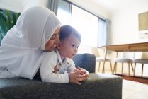 Mutter im Hijab spielt mit ihrem Sohn im Wohnzimmer — Stockfoto