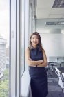 Young asian business woman at window at modern office — Stock Photo