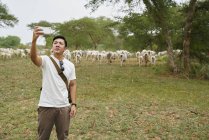 Giovane che si fa un selfie con un gruppo di mucche . — Foto stock