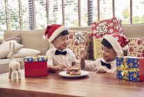 Feliz asiático familia celebrando navidad juntos, dos chicos con navidad galletas - foto de stock