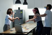 Jovem asiático colegas ter diversão com engraçado óculos de sol no moderno escritório — Fotografia de Stock