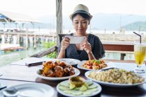 LIBERTAS Jovem turista tirar fotos de sua refeição em Koh Chang, Tailândia — Fotografia de Stock