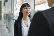 Young asian business couple looking at each other in office — Stock Photo
