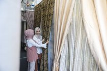 Due signore musulmane che comprano tende . — Foto stock