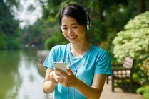 Portrait of woman listening to music while walking in Botanic Gardens — Stock Photo