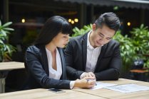 Young asian business couple working together in cafe — Stock Photo
