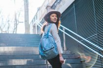 Young attractive asian woman with backpack on stairs — Stock Photo