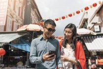 Азиатская китайская пара проводит время вместе в Китайском квартале со смартфоном — стоковое фото