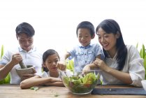 Feliz asiático família preparando comida juntos em casa — Fotografia de Stock