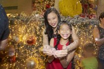 Азіатська мати і дочка розважаються на різдвяній вечірці — стокове фото