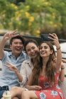 Group of young asian friends taking selfie outdoors — Stock Photo