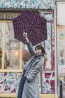 Trendy stylish woman posing at city street with umbrella — Stock Photo