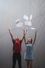 Jóvenes asiático universidad estudiantes tirar papel en el aire - foto de stock