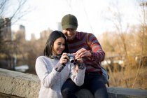 Joven asiático pareja de turistas mirando en cámara en central park, Nueva York, EE.UU. - foto de stock