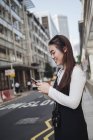 Mulher de cabelo longo chinesa bonita com smartphone na rua — Fotografia de Stock