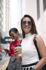 Young asian female friends together on city street — Stock Photo