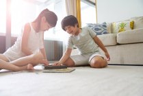 Glückliche junge asiatische Familie zusammen, Kinder beim Scrabbeln zu Hause — Stockfoto