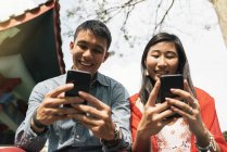 Ásia chinês casal passar tempo juntos no Chinatown olhando para smartphones — Fotografia de Stock