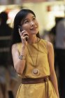 Feliz asiático joven mujer hablando en smartphone - foto de stock