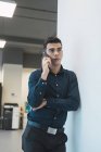 Успішний бізнесмен розмовляє по телефону в сучасному офісі — стокове фото