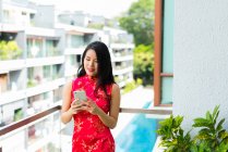 Heureux asiatique femme en utilisant smartphone sur balcon — Photo de stock